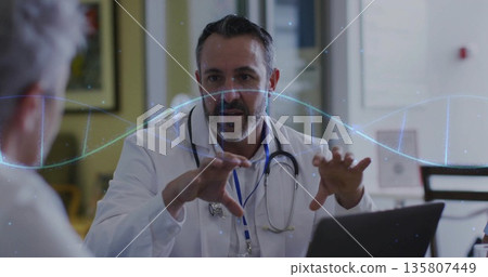 Discussing male doctor explaining plan in clinic, with laptop, stethoscope and digital wave graphic 135807449