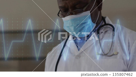 Reviewing doctor viewing ECG overlay in clinic with lab coat, mask and stethoscope, copy space Reviewing doctor viewing ECG overlay in clinic with lab coat, mask and stethoscope, copy space 135807462