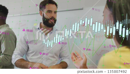 Presenting mid adult male in shirt explaining financial graphs at office with chart overlays Presenting mid adult male in shirt explaining financial graphs at office with chart overlays 135807492