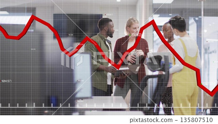 Discussing office professionals analyzing red line chart overlay in office with laptop, monitors Discussing office professionals analyzing red line chart overlay in office with laptop, monitors 135807510