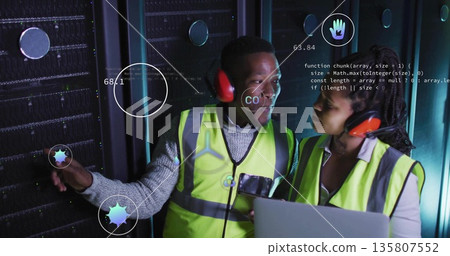Two technicians wearing vests diagnosing racks in data center aisle, with laptop and data icons Two technicians wearing vests diagnosing racks in data center aisle, with laptop and data icons 135807552