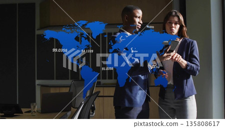 Analyzing professionals in business attire reviewing tablet data in office, with floating world map Analyzing professionals in business attire reviewing tablet data in office, with floating world map 135808617
