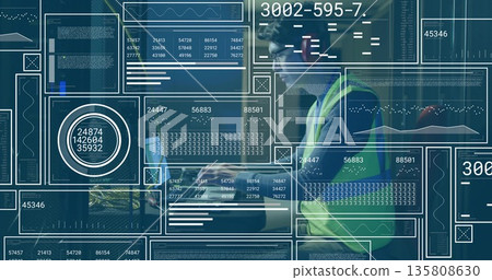 Monitoring technician in vest analyzing laptop data at warehouse station, data panels, copy space Monitoring technician in vest analyzing laptop data at warehouse station, data panels, copy space 135808630