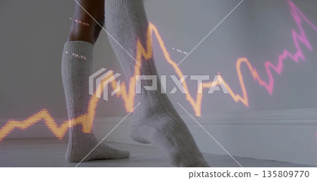 Feet wearing knee-high cable-knit socks stepping on wooden floor in room, with neon chart overlay 135809770