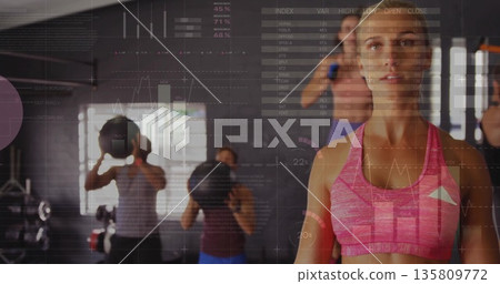 White woman wearing pink sports bra holding medicine ball in gym studio, with earphones, copy space White woman wearing pink sports bra holding medicine ball in gym studio, with earphones, copy space 135809772