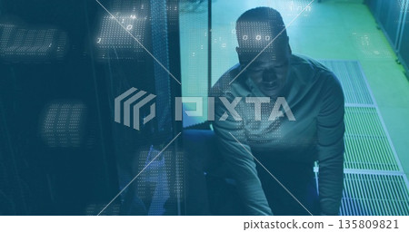 Squatting technician plugging cables at server rack in data center, binary code overlay, copy space 135809821