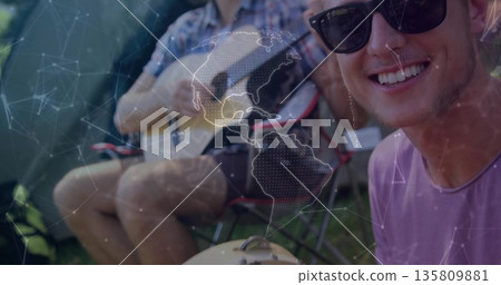 Smiling man wearing sunglasses, purple tee sitting at campsite with guitar and grill, copy space Smiling man wearing sunglasses, purple tee sitting at campsite with guitar and grill, copy space 135809881