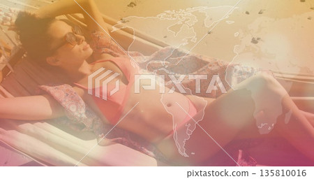 Relaxing adult woman soaking up sun on beach chair, with pink bikini sunglasses patterned cover-up Relaxing adult woman soaking up sun on beach chair, with pink bikini sunglasses patterned cover-up 135810016