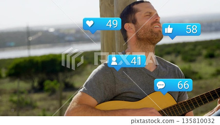Strumming musician in gray tee by wooden post at shore, with acoustic guitar and floating icons Strumming musician in gray tee by wooden post at shore, with acoustic guitar and floating icons 135810032