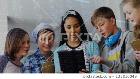 Collaborating five students coding on tablet in classroom, with notebooks and headphones Collaborating five students coding on tablet in classroom, with notebooks and headphones 135810049