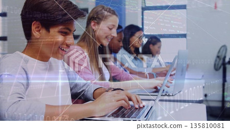Typing teenage boy in grey shirt at laptop in computer lab, with data overlays, copy space Typing teenage boy in grey shirt at laptop in computer lab, with data overlays, copy space 135810081