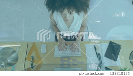 Typing woman in white sleeveless top at office desk, with wireless keyboard and graphics overlay Typing woman in white sleeveless top at office desk, with wireless keyboard and graphics overlay 135810135