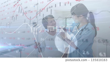 Nurse in scrubs placing stethoscope on patient shoulder at clinic, with cane and market charts 135810163