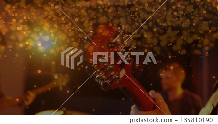 Focusing red electric guitar headstock showing silver tuning pegs on stage, golden bokeh 135810190