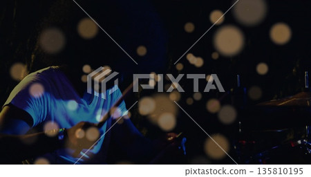 Playing Indian drummer delivering rhythms on venue stage, with drum kit, drumsticks, bokeh orbs Playing Indian drummer delivering rhythms on venue stage, with drum kit, drumsticks, bokeh orbs 135810195