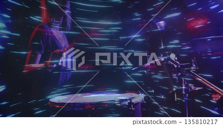 Playing percussionist striking snare drum with drumstick on concert stage, light trails, copy space Playing percussionist striking snare drum with drumstick on concert stage, light trails, copy space 135810217
