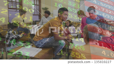 Teenage classmates collaborating around desks in classroom with finance data overlay and notebooks 135810227