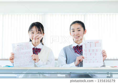 Female junior high school student showing answer sheet Female junior high school student showing answer sheet 135810279
