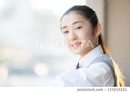 放學後,一名國中女生向窗外望去。 放學後,一名國中女生向窗外望去。 135810281