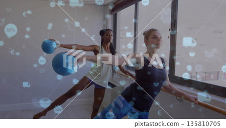 Balancing partners stretching at barre by fitness studio windows, with balls and floating icons Balancing partners stretching at barre by fitness studio windows, with balls and floating icons 135810705