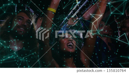 Cheering woman wearing bucket hat, wristbands raising arms at night concert, friends holding phones Cheering woman wearing bucket hat, wristbands raising arms at night concert, friends holding phones 135810764