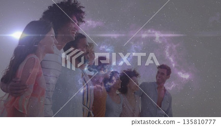 Standing group of eight friends linking arms and smiling in open field under cosmic nebula Standing group of eight friends linking arms and smiling in open field under cosmic nebula 135810777