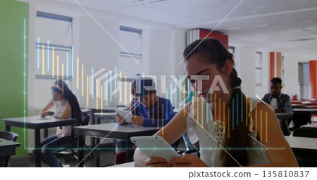 Focusing teenage girl with headphones using tablet at school desks near windows, copy space 135810837