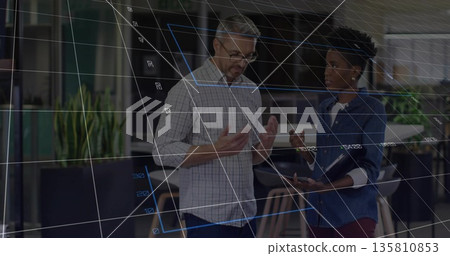 Collaborating coworkers analyzing data with stylus in open office, with data grid overlay Collaborating coworkers analyzing data with stylus in open office, with data grid overlay 135810853