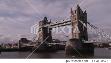 Displaying Tower Bridge spanning River Thames in London, with towers, cables, walkway and boat 135810876