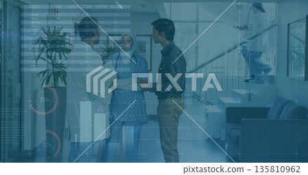 Reviewing doctor, nurse, consultant examining records in hospital lobby, with stethoscope tablet 135810962