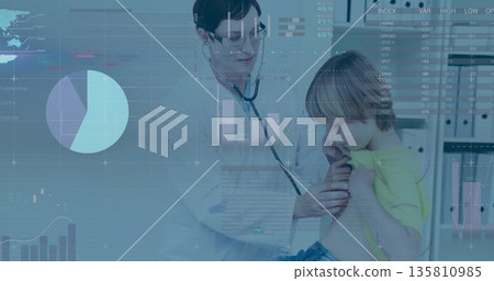 Listening doctor pressing stethoscope on school-age boy's chest in clinic, with digital charts 135810985