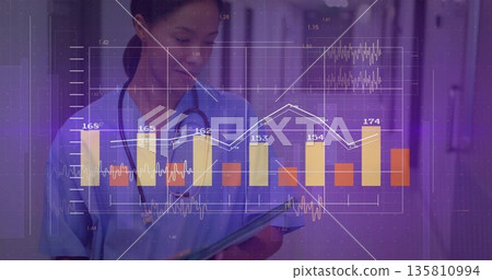 Nurse in blue scrubs, stethoscope reviewing tablet in hospital corridor, overlaid bar, line graphs Nurse in blue scrubs, stethoscope reviewing tablet in hospital corridor, overlaid bar, line graphs 135810994