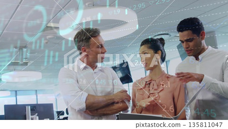 Analyzing professionals wearing business attire reviewing charts on monitors in office with tablet Analyzing professionals wearing business attire reviewing charts on monitors in office with tablet 135811047