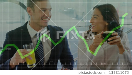 Smiling professionals sipping orange juice and coffee at breakroom counter, showing graph overlay 135811073