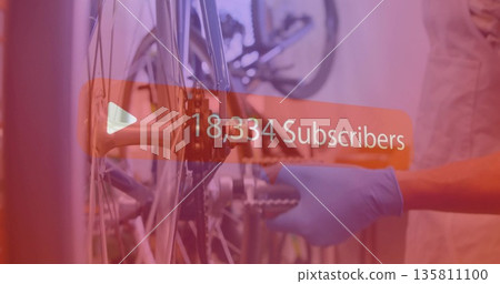 Adjusting mechanic wearing gloves tightening bicycle hub in workshop with sprocket wrench overlay Adjusting mechanic wearing gloves tightening bicycle hub in workshop with sprocket wrench overlay 135811100