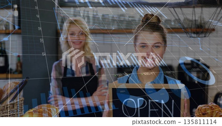 Holding chalkboard sign, aproned baker presenting open sign at counter, bread baskets and pastries 135811114