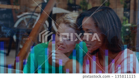 Colleagues wearing green sweater pink top studying charts at office table, with bicycle frame plant Colleagues wearing green sweater pink top studying charts at office table, with bicycle frame plant 135811115