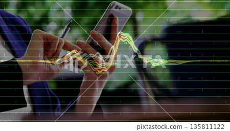 Analyzing woman in blazer holding smartphone and pen at office window desk with line graph overlay 135811122