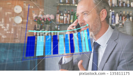 Businessman talking on smartphone, gesturing at bar counter, with rising chart overlay, copy space Businessman talking on smartphone, gesturing at bar counter, with rising chart overlay, copy space 135811175