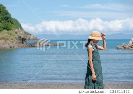 A woman walking along the beach 135811331