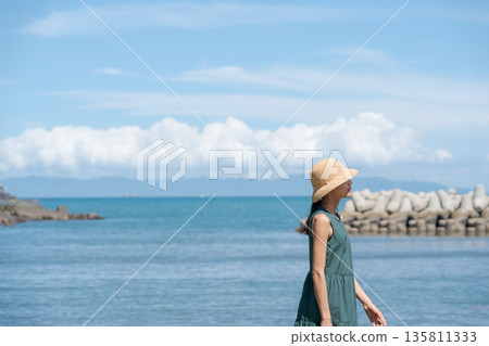 一個女人在沙灘上散步 135811333