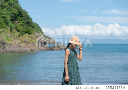 A woman walking along the beach 135811334