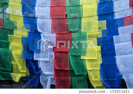Prayer flags hanging in sacred place in rural Nepal. The prayer flags initiate peace and good tidings, their sacred mantras etched on the wind. Prayer flags hanging in sacred place in rural Nepal. The prayer flags initiate peace and good tidings, their sacred mantras etched on the wind. 135811651