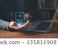 person holds glowing AI-powered digital documents while using a laptop, symbolizing artificial intelligence, automation, data processing, smart approval, and innovation in digital document management. 135811908