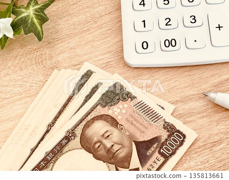 錢(一疊10,000日元鈔票)和一個白色計算器 錢(一疊10,000日元鈔票)和一個白色計算器 135813661