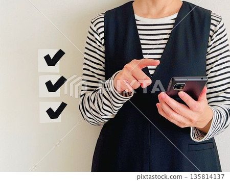 一位女性正在用智慧型手機處理任務 135814137