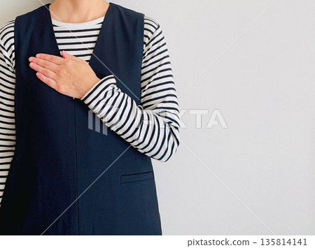 A woman putting her hand on her chest A woman putting her hand on her chest 135814141