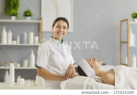 Cosmetologist with client for skincare therapy in spa beauty salon, portrait of standing beautician Cosmetologist with client for skincare therapy in spa beauty salon, portrait of standing beautician 135814169