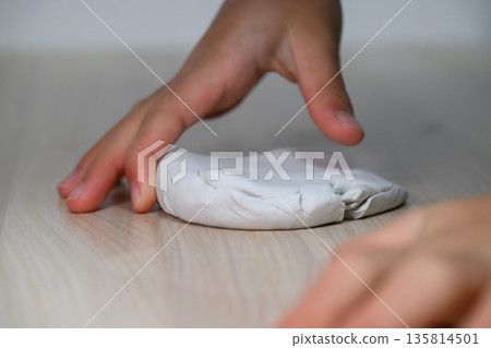 A child's hands flattening the clay A child's hands flattening the clay 135814501