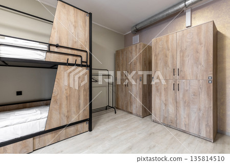 Hostel dormitory with private bunk beds and large wooden lockers 135814510
